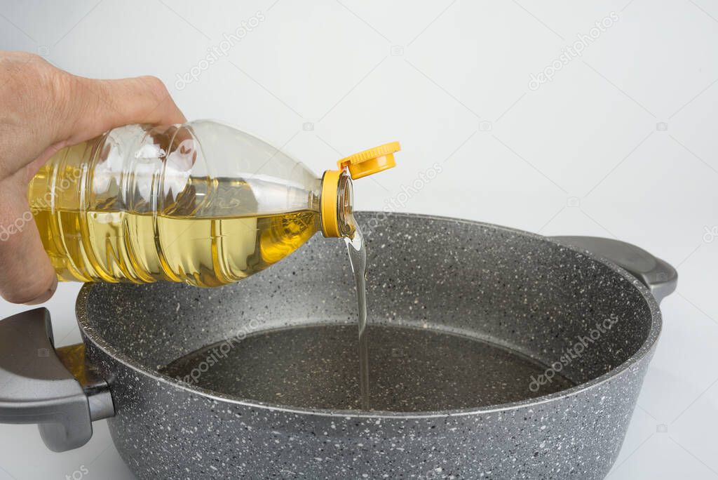 Vegetable oil in plastic bottle pouring in the pan