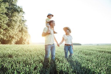 mutlu bir aile küçük bir çocukla güneşli resimleri. Anne ve oğlu dinlenme açık havada şehir dışında
