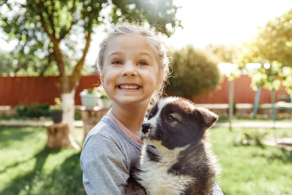 küçük kız bir köpek ile oynuyor. çocuklar için bir hediye olarak bir köpek. Çocuk gülümseme niteliğine