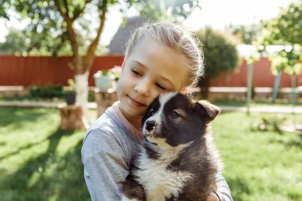 küçük kız bir köpek ile oynuyor. çocuklar için bir hediye olarak bir köpek. Çocuk gülümseme niteliğine