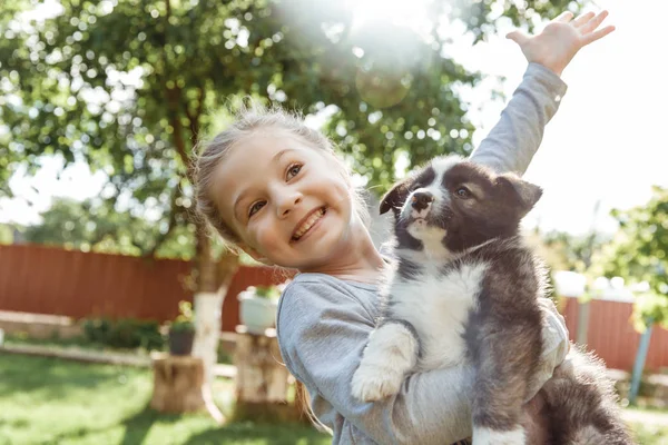 küçük kız bir köpek ile oynuyor. çocuklar için bir hediye olarak bir köpek. Çocuk gülümseme niteliğine