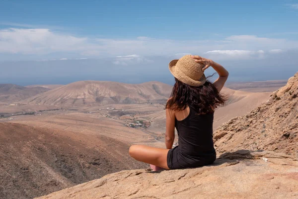relaxed girl looking at a landscape from the top of a mountain, fuerteventura