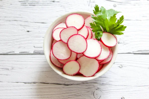 Closeup radish slices in the bowl. Raw organic radish chips slices ready to eat.