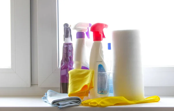 Plastic basket with bottles of dishwashing liquid. Cleaning set.