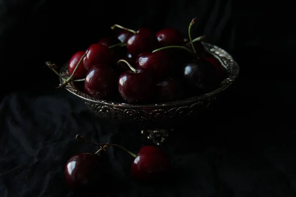 Cerejas maduras doces frescas em prato rústico no fundo preto. Fechar. — Fotografia de Stock