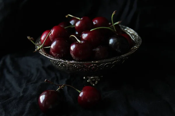 Cerejas maduras doces frescas em prato rústico no fundo preto. Fechar. — Fotografia de Stock