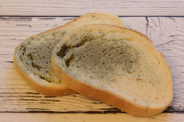 Pleśń szybko rosnę na spleśniały chleb na drewniany tło. Pleśń na plasterku chleba. Gęsty chleb, pokryty pleśnią. — Zdjęcie stockowe