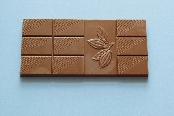 밀크 초콜릿은 위에서 부터푸른 배경에 분리되어 있습니다. 파란 배경에 고립된 초콜릿 바를 닫는다. — 스톡 사진