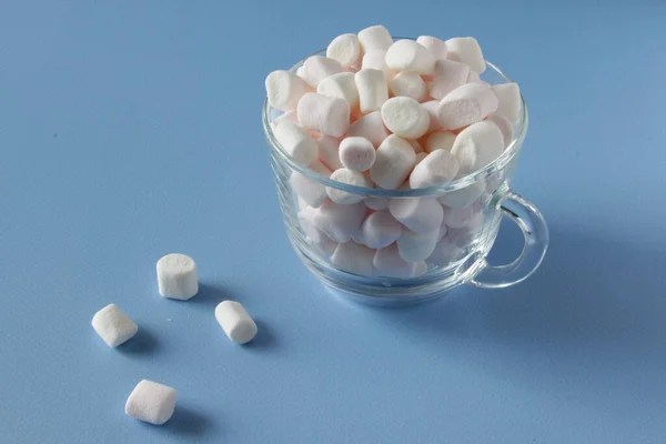 Vit fluffiga marshmallows i vit kopp isolerad på blå bakgrund. Mini marshmallows. Vintermat bakgrund koncept. — Stockfoto