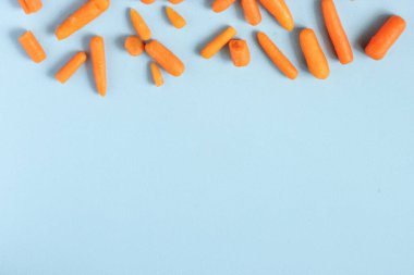 Donmuş sebzeler, mesela bebek havuçlar gibi mavi arka planda, fotokopi alanı ile sıralanmış. Üst Manzara. Yatay yönelim