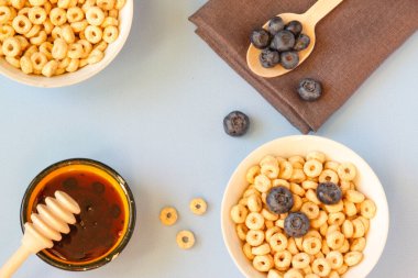 Mavi arka plandaki kasede yaban mersinli bal halkaları. Uzayı kopyala Üst Manzara. Düz yatıyordu. Yatay yönelim.