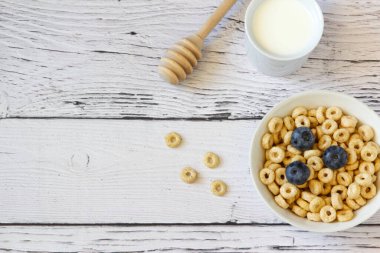 Ahşap arka planda yaban mersini ve sütle bal halkaları. Uzayı kopyala Üst Manzara. Düz yatıyordu. Yatay yönelim.