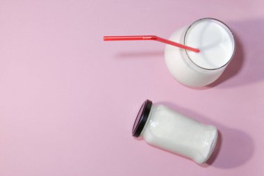 Airan ya da kefir içeceği, mayalanmış süt içeceği, pembe arka planda fotokopi alanı olan fermente edilmiş probiyotikler. Sağlıklı gıda konsepti. Üst görünüm.