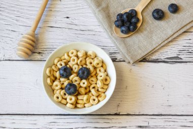 Sağlıklı kahvaltı. Masanın üzerinde böğürtlenli bal halkaları ve ahşap arka plan. Uzayı kopyala Yatay oryantasyon. Üst Manzara. Düz yatıyordu