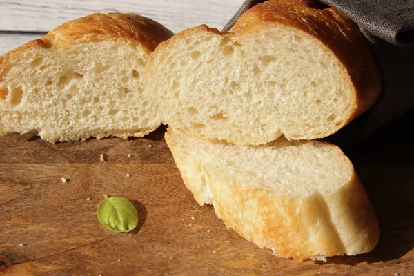 法国新鲜的软面包面包面包面包在木制切菜板上 几块切下来的碎片相邻而立 横向方向 — 图库照片
