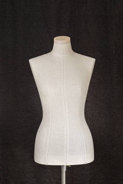 Kadın manken gri kumaş kaplı. Siyah arka plan.