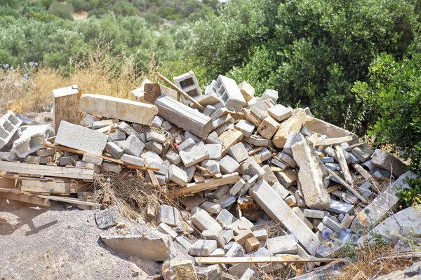 Construction and Demolition Debris. Background of olive trees.