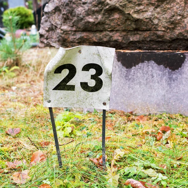 Platte mit der Zahl 23 in den Boden geklebt. — Stockfoto