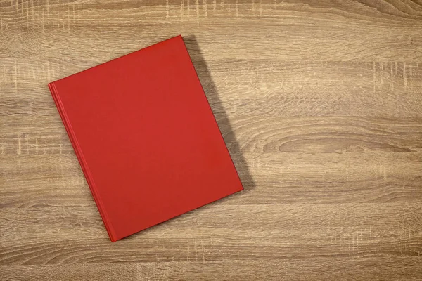 Libro rojo sobre la mesa de pino marrón —  Fotos de Stock