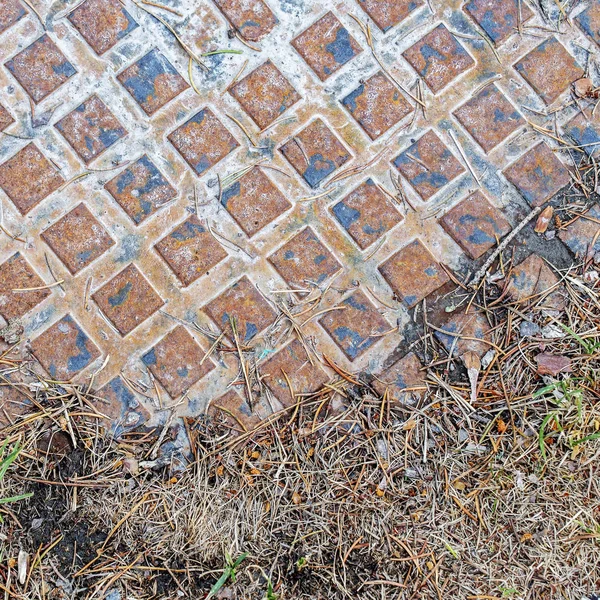 Parte de la tapa metálica de alcantarilla. Pavimento en el parque . — Foto de Stock