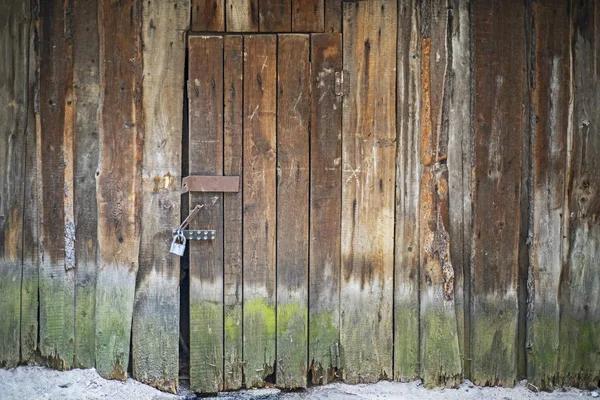 Old weathered wooden closed and locked door. — Stock Photo, Image