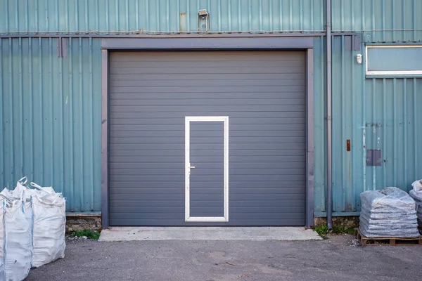 Magazzino industriale con porta grigio scuro per veicolo . — Foto Stock