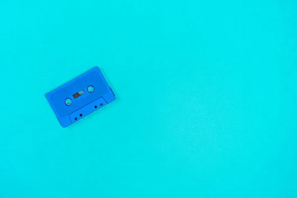 Retro modré plastové audio kazeta na zelený kovový stůl. — Stock fotografie
