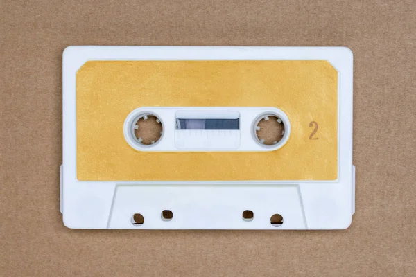 Cinta de audio blanca retro con etiqueta amarilla sobre fondo marrón. Lado 2 . — Foto de Stock