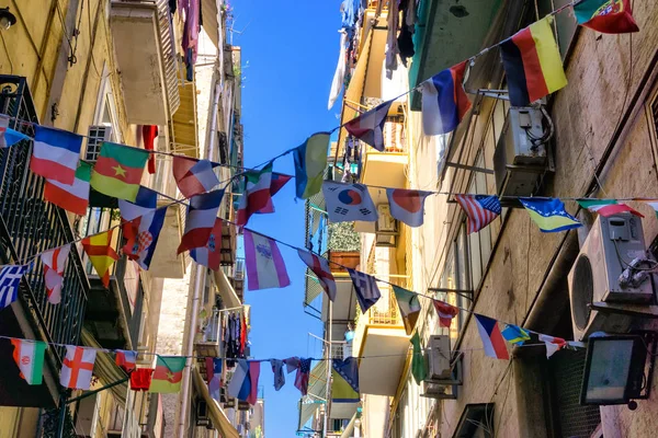 さまざまな国の国旗を飾るイタリア ナポリの街の中心部の通り — ストック写真