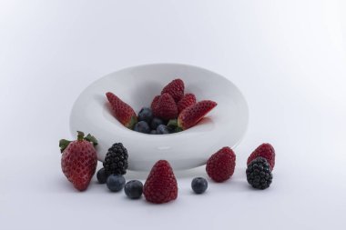 Beyaz bir arka plan üzerinde beyaz bir tabak taze çilek. -Imagen