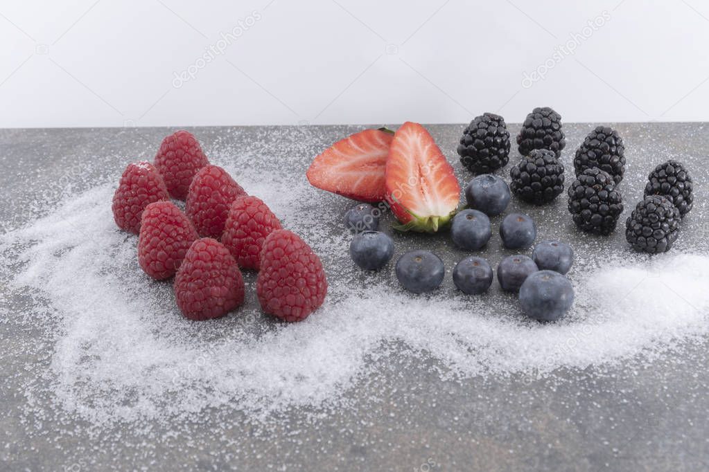 Fresh berries and  on a plate of granite whith sugar on a white background.  - Imagen