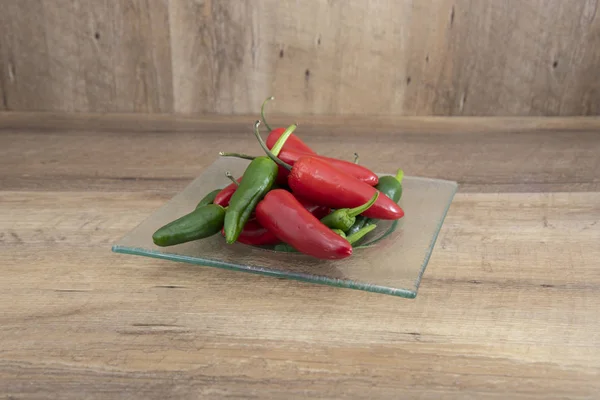 taze yeşil jalapeno ve bir plaka ile ahşap bir arka plan üzerinde kırmızı biber