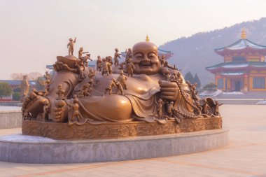 Buda heykeli ve dua ve oynayan çocuklar