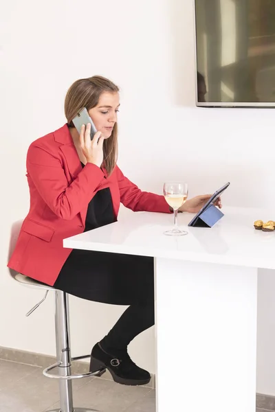 Mulher loira fala ao telefone sentado na sala de descanso . — Fotografia de Stock