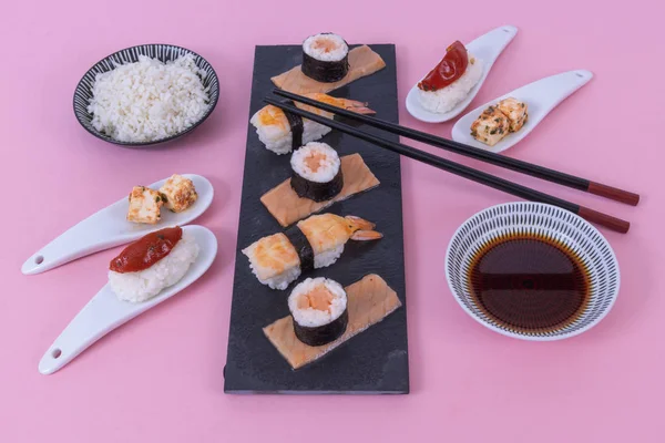 Asijské potraviny na černý kámen břidlice s hůlkami — Stock fotografie