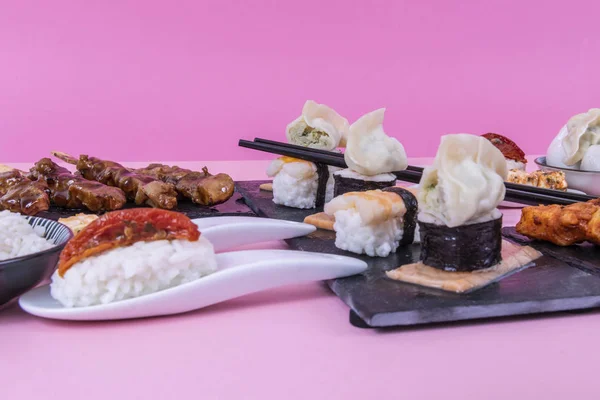 Ασιατικές τρόφιμα στη μαύρη πέτρα σχιστόλιθος με chopsticks — Φωτογραφία Αρχείου