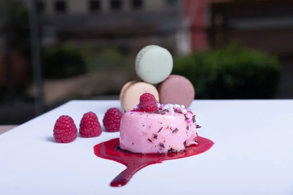 elegant berry tart, colorful macaroons and fresh berries. Blurred background