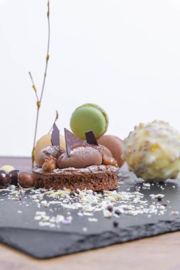 Belçika çikolatası, bisküvi gevrek ve vanilyalı krema. Siyah bir tabakta ve beyaz arka planda