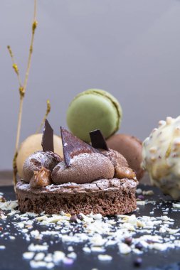 Belçika çikolatası, bisküvi gevrek ve vanilyalı krema. Siyah bir tabakta ve beyaz arka planda