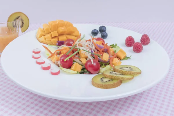 Sabrosa ensalada mixta con tomates cherry frescos, mango, lechuga y pepino sobre un fondo blanco —  Fotos de Stock