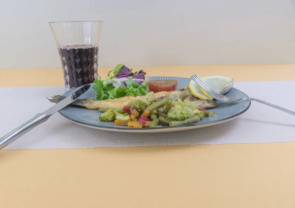 Grilled fish with steamed vegetables and fresh salad.