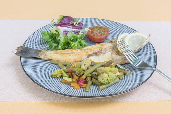 Grilled fish with steamed vegetables and fresh salad.