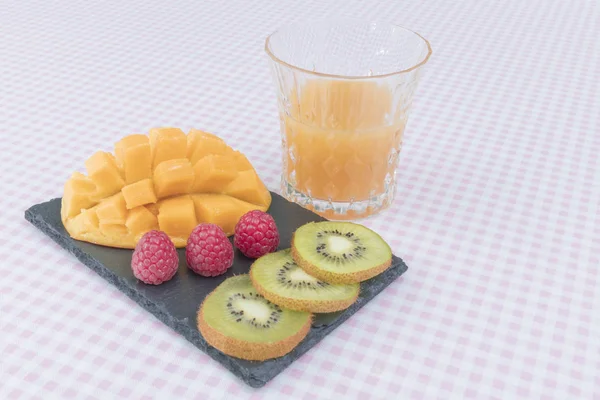 Фруктовая тарелка с ягодами, манго и киви. Вкусный фруктовый пунш. Селективный фокус — стоковое фото