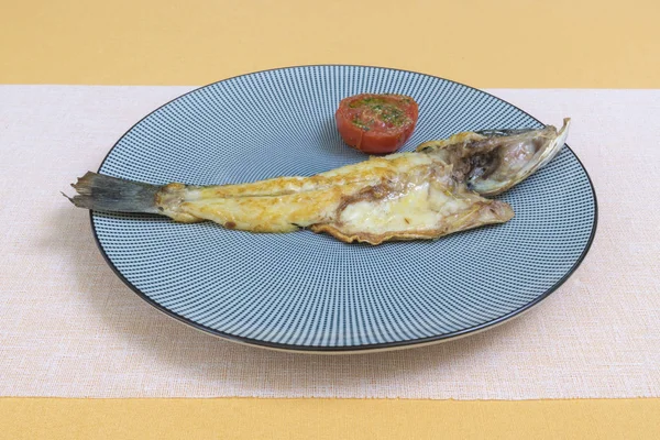 Ψητά ψάρια σε λευκή πλάκα με ντομάτες σε πιάτο — Φωτογραφία Αρχείου