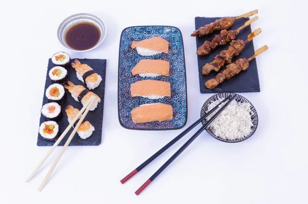 Sushi rolky, lososí sushi rolka, sójová omáčka, bílá rýže, hůlky a bílé pozadí — Stock fotografie