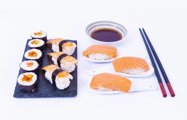 Sushi rolky, lososí sushi rolka, sójová omáčka, bílá rýže, hůlky a bílé pozadí — Stock fotografie