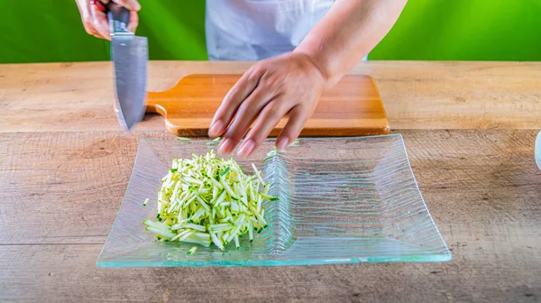 Chef che prepara zucchine julienne. strisce di zucchine su un piatto di vetro — Foto Stock