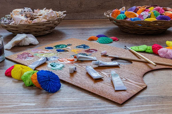 Beautiful composition of painted sea shells and wood background . Abstraction, sea theme, nature, travel, science, beauty.