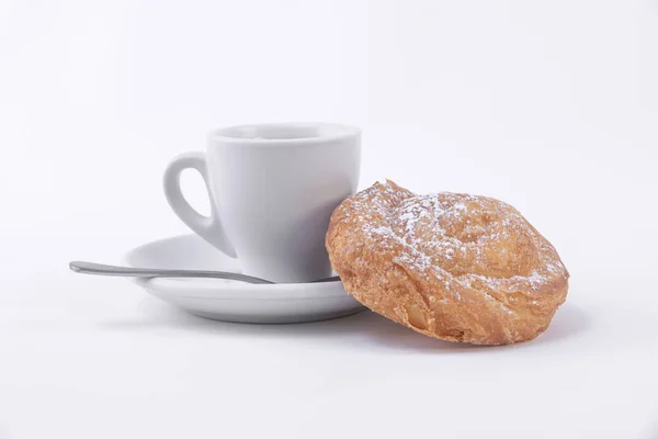 Eine Tasse heißen Kaffee und eine Rolle Blätterteig mit Puderzucker — Stockfoto