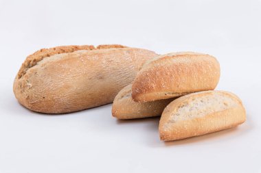 Beyaz arka planda küçük somun ekmek ile ev yapımı kepekli ekmek